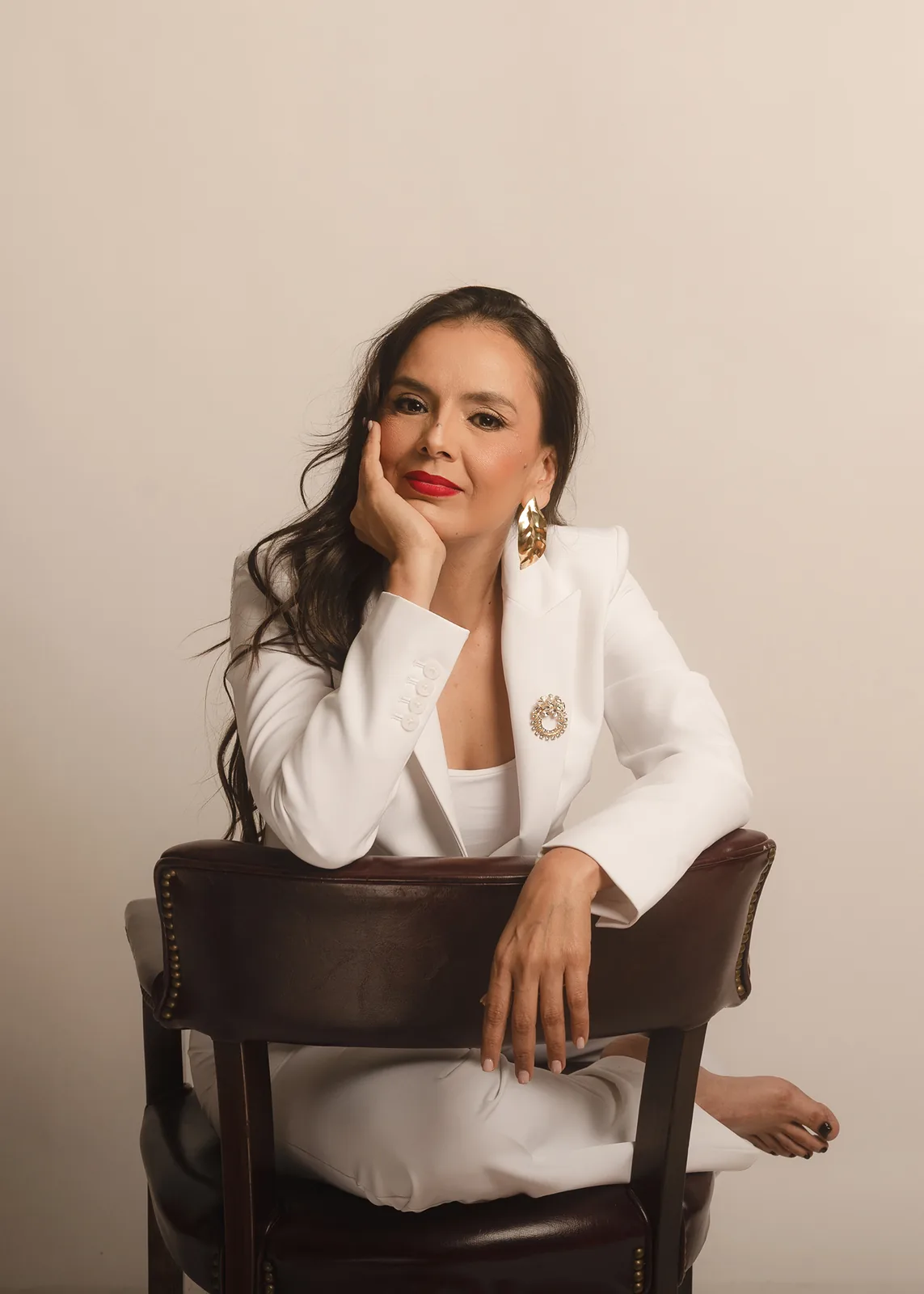 Talia Palafox sentada, con la mano en la mejilla, mirando a cámara